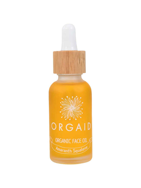 A 30ml glass bottle of Orgaid Organic Face Oil Amaranth Squalene with a wooden dropper cap contains yellow-orange amaranth squalene, features a white floral design, and has "Amaranth Squalene" labeled on the front.