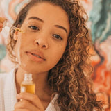 Woman applying Orgaid Organic Face Oil with a dropper
