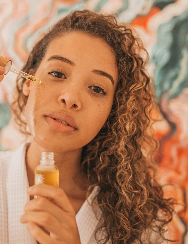 Woman applying Orgaid Organic Face Oil with a dropper