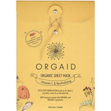 Golden-yellow Orgaid Vitamin C and Revitalising sheet-mask envelope with a string-and-button fastening, a black flower emblem and fine botanical drawings along the lower corners.