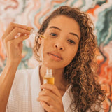 Woman applying Orgaid Organic Face Oil with a dropper