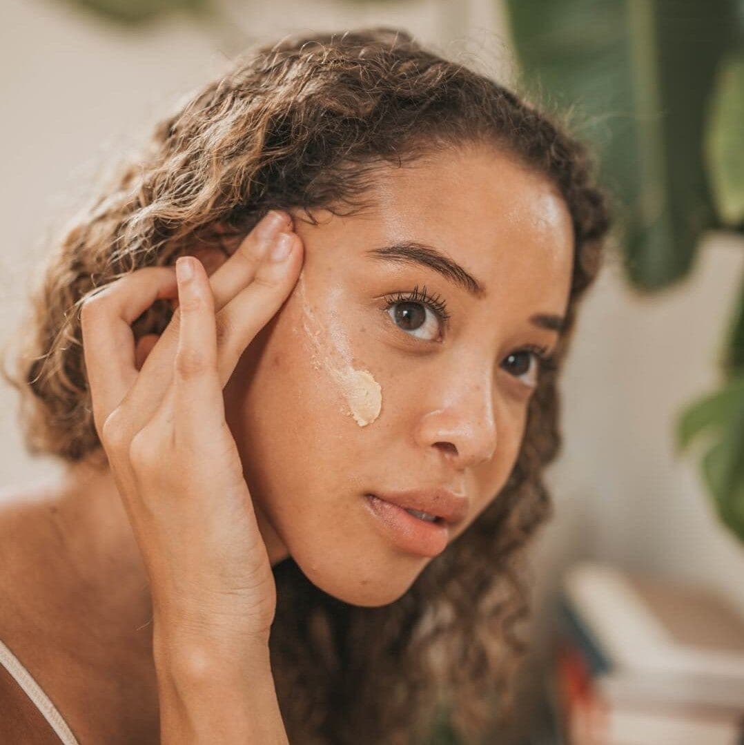 Woman applying Orgaid Purifying Face Polish to her cheek