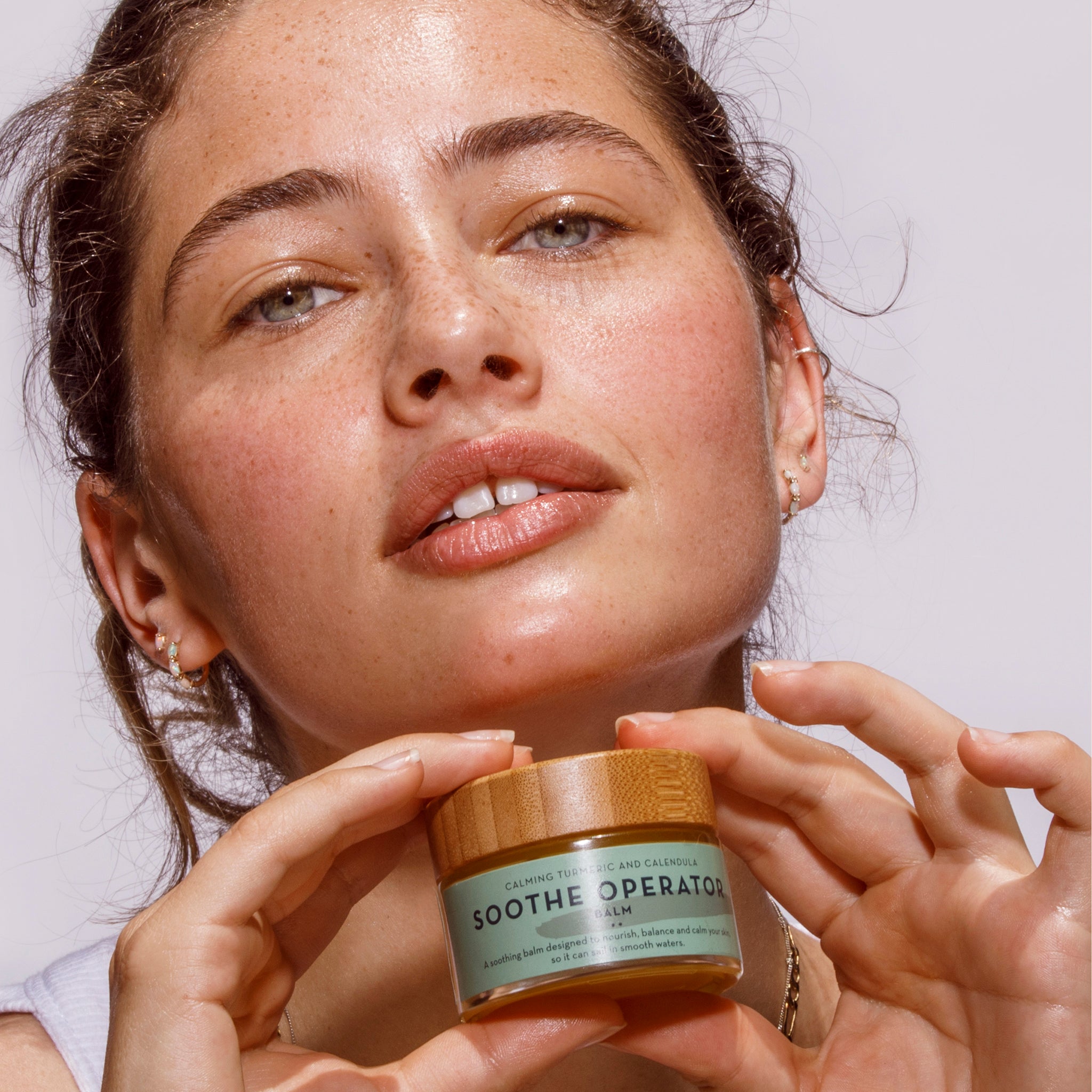Woman holding The Organic Skin Co Soothe Operator Balm