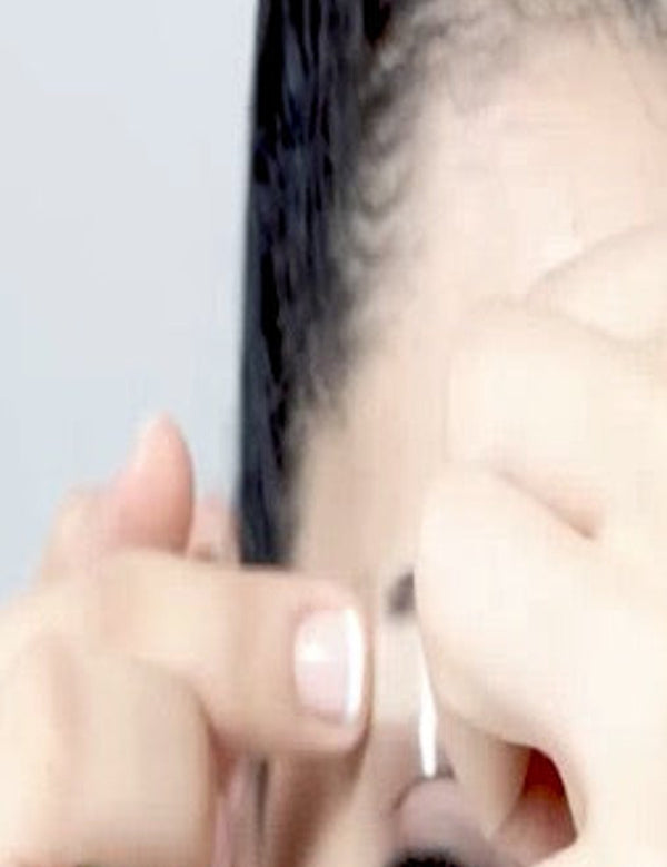 Close-up of a Parissa Brow Wax Strip being positioned and pressed along the eyebrow.