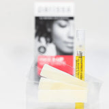 Several pale wax strips and a slim yellow-labelled tube arranged in front of a blurred Parissa Face and Lip Wax Strips box.