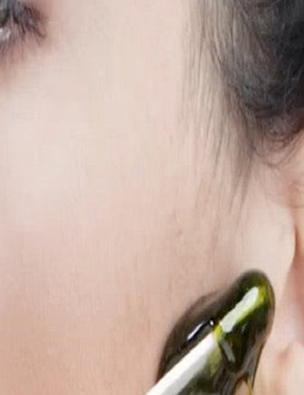 Parissa No-Strip Hot Wax being carefully applied to facial skin with a slim wooden applicator.