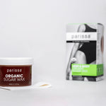 Parissa Organic Sugar Wax jar with a white lid beside a small white spatula, with its green-panel box in the background.
