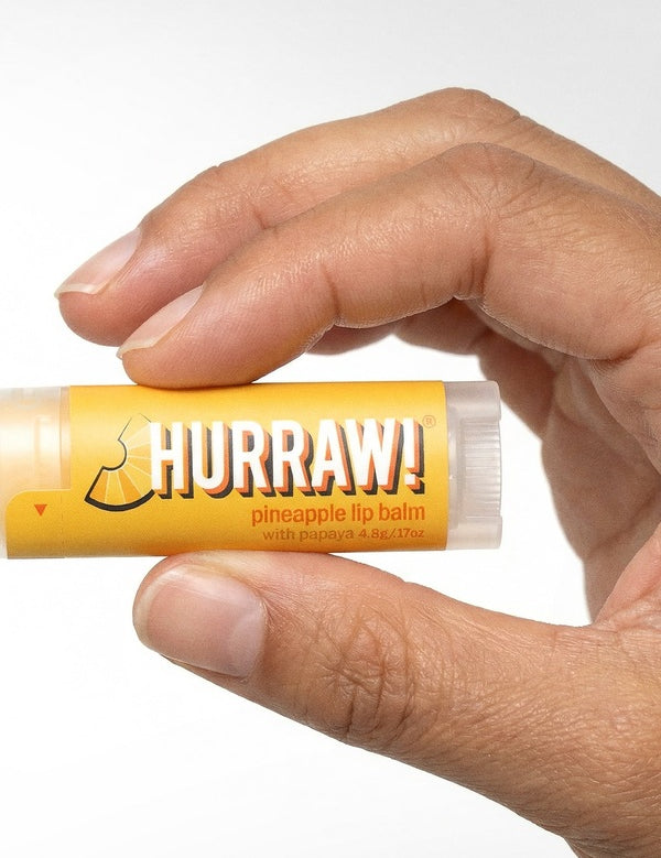 Hand holding Hurraw! Organic Lip Balm - Pineapple 4.8g