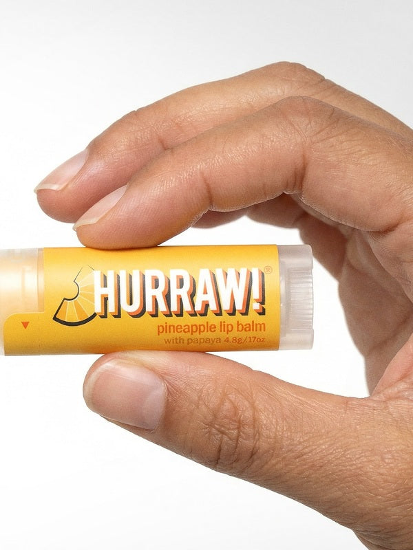 Hand holding Hurraw! Organic Lip Balm - Pineapple 4.8g