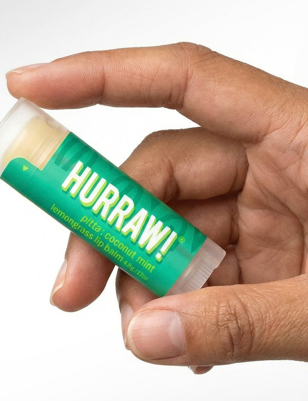 Hand holding Hurraw! Pitta Lip Balm Coconut Mint & Lemongrass 4.8g