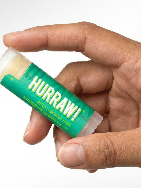 Hand holding Hurraw! Pitta Lip Balm Coconut Mint & Lemongrass 4.8g
