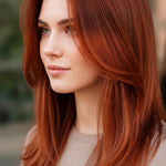Woman modelling Radico Auburn Red hair colour, with long, smooth copper-red hair parted in the centre and curved layers framing her face and shoulders.