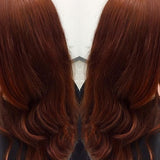 Two rear views of glossy dark auburn hair with loose curls at the ends, shown side by side with the shade name Auburn Red beneath.
