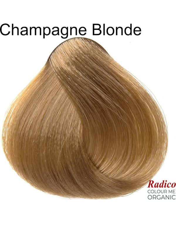 Rounded teardrop-shaped tuft of smooth, muted golden-beige hair beneath the shade name Champagne Blonde, with the Radico Colour Me Organic logo at the lower right.