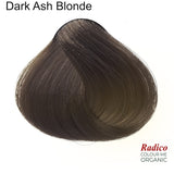 Rounded teardrop-shaped tuft of smooth, cool dark grey-brown hair beneath the shade name Dark Ash Blonde, with the Radico Colour Me Organic logo at the lower right.