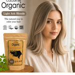 Radico Light Ash Blonde graphic showing a woman with smooth beige-brown hair and pale ash-blonde strands beside a brown paper hair-colour pouch, with the shade name on a grey-brown brushstroke above.