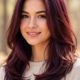Smiling woman modelling Radico Wine Red hair colour, with glossy burgundy-red layers curving inward around her shoulders and brighter red highlights near the crown.