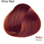 Rounded teardrop-shaped tuft of smooth, deep red hair with copper-red highlights beneath the shade name Wine Red, with the Radico Colour Me Organic logo at the lower right.