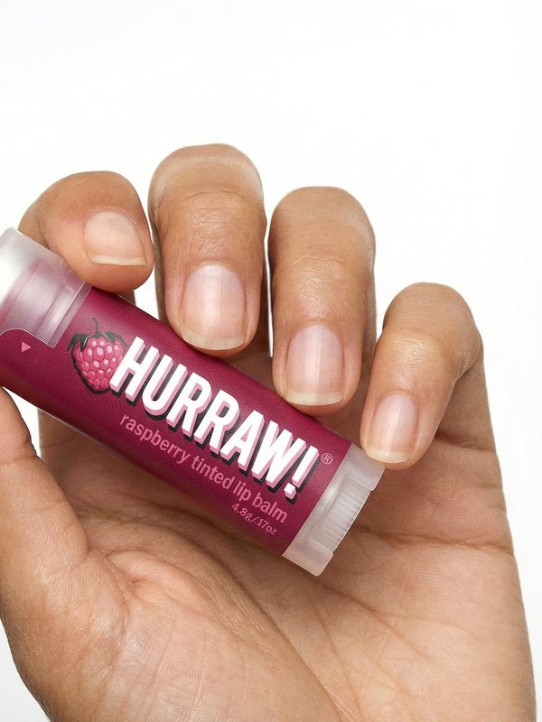 Hand holding Hurraw! Organic Lip Balm - Raspberry 4.8g