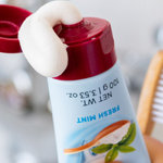Red Seal Baking Soda Hydroxyapatite Toothpaste being squeezed beside a toothbrush