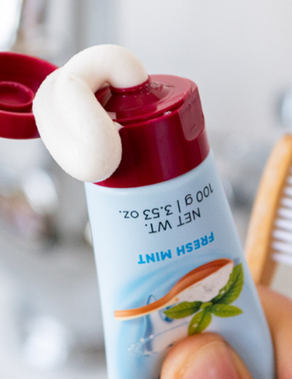 Red Seal Baking Soda Hydroxyapatite Toothpaste being squeezed beside a toothbrush