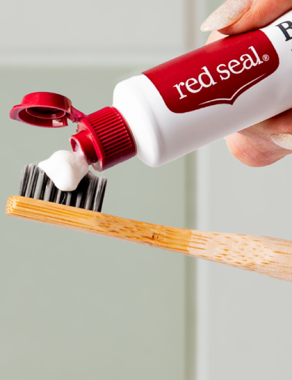 Red Seal Baking Soda Toothpaste being applied to a toothbrush