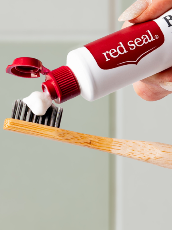 Red Seal Baking Soda Toothpaste being applied to a toothbrush