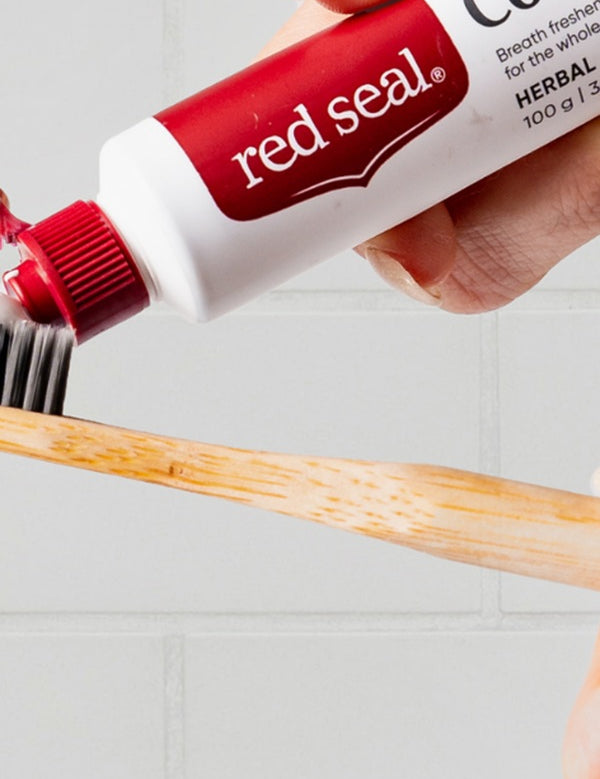 Red Seal Complete Care Toothpaste being applied to a toothbrush