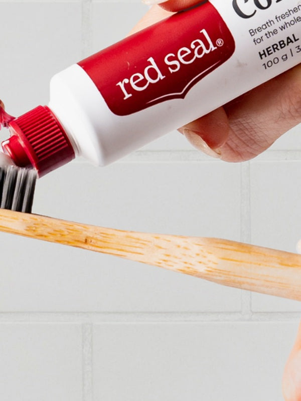 Red Seal Complete Care Toothpaste being applied to a toothbrush