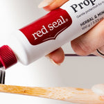 Red Seal Propolis Toothpaste being applied to a toothbrush