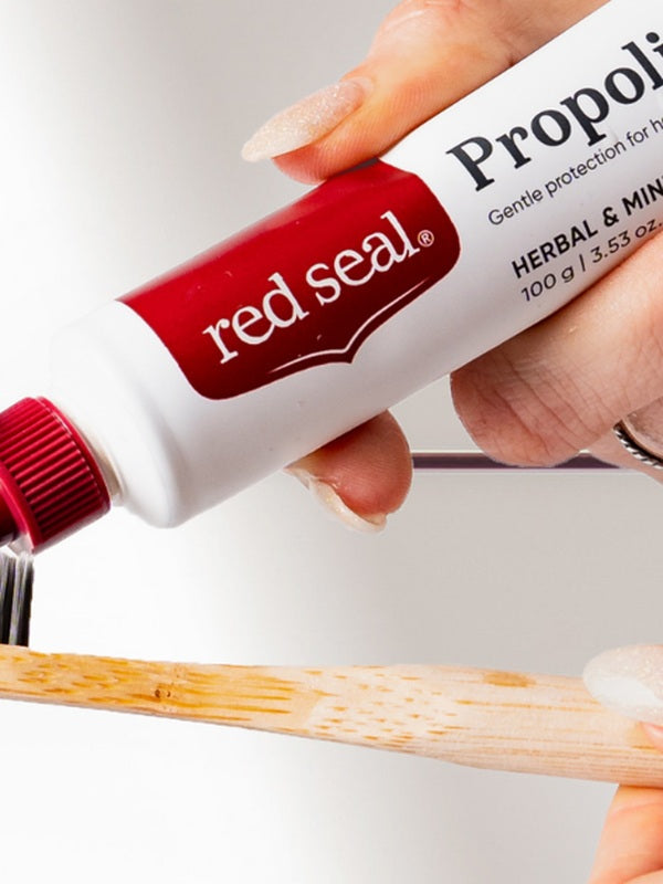 Red Seal Propolis Toothpaste being applied to a toothbrush