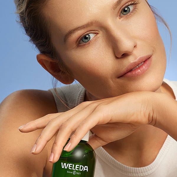 Young woman holding Refining Toner in her hands.
