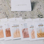 Six sachets of loose Eco Minerals Flawless Matte Mineral Foundation 5g in assorted shades are displayed on marble, with a white ecominerals box behind them, showcasing their flawless matte finish.
