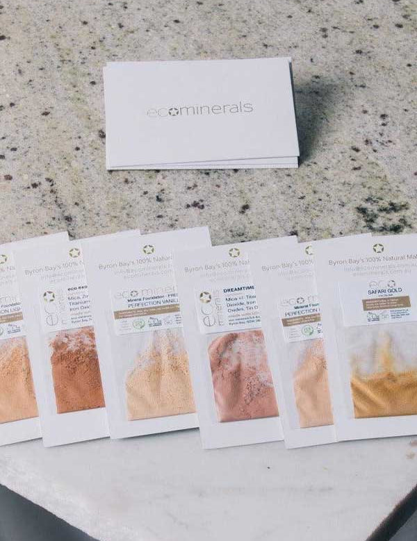 Eco Minerals Flawless Matte Mineral Foundation 5g is shown in six sample shades on a light countertop, with a white Eco Minerals box behind them. Enjoy natural matte finish and gentle daily coverage.
