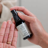 Sanctum HY C Recovery Serum being pumped from the bottle into an open palm.