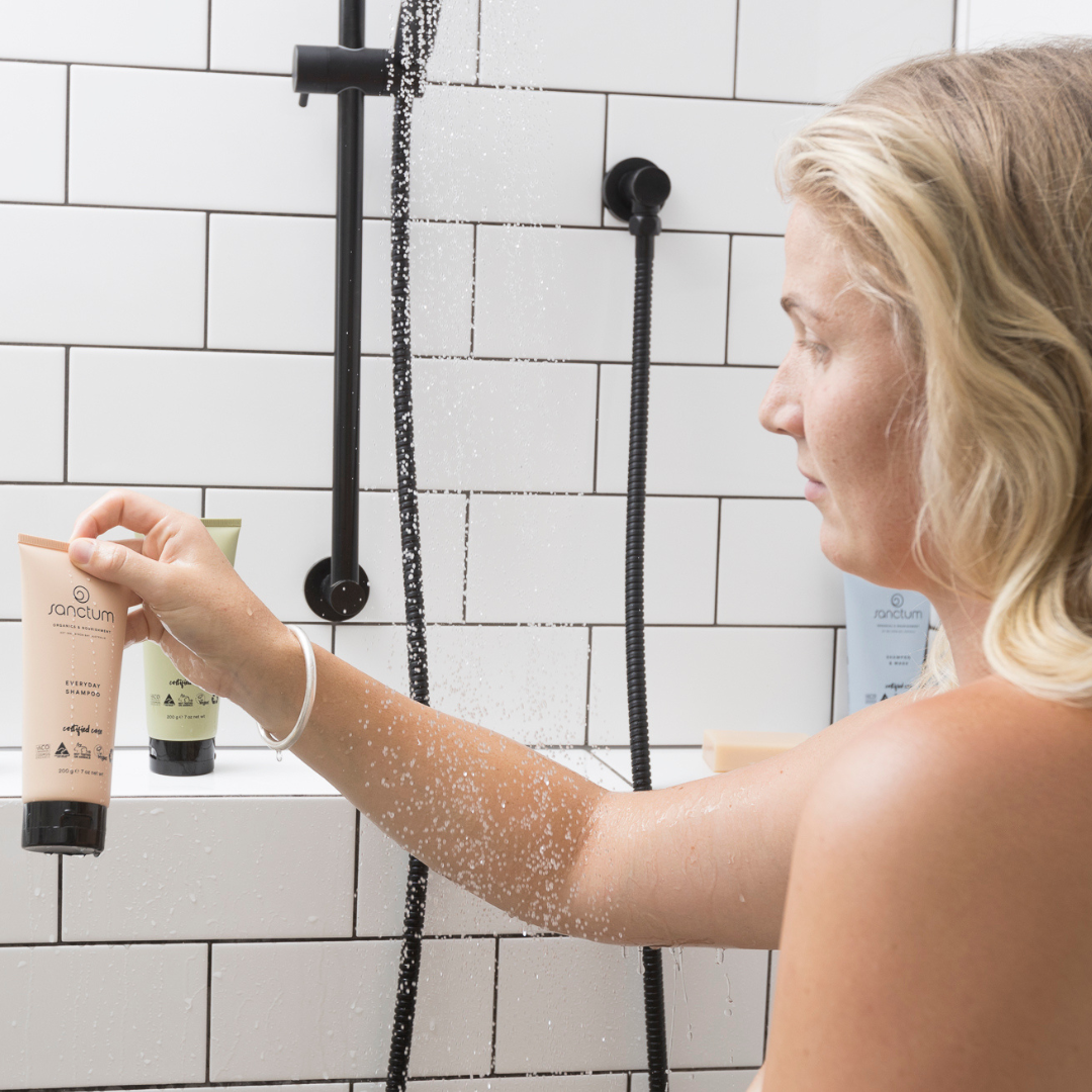 Woman using Sanctum Everyday Shampoo in the shower