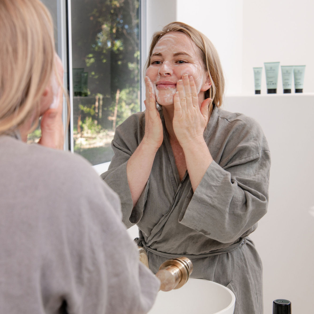 Woman cleansing her face with Sanctum Purifying Foam Cleanser