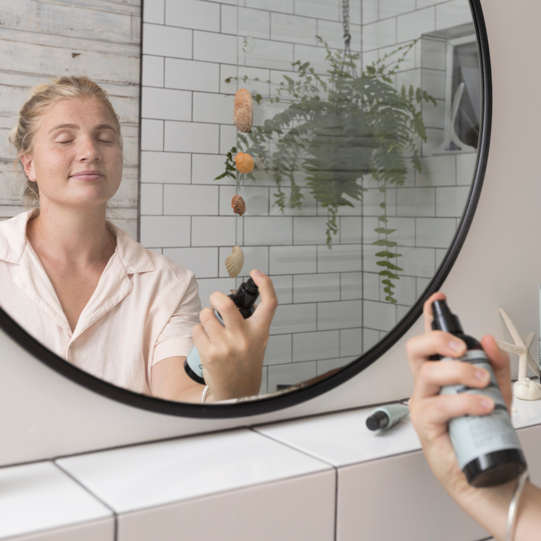 Woman misting her face with Sanctum Tone and Refresh Mist