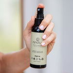 Hand holding Sanctum Women's Deodorant Spray upright with the front label facing the camera.