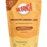 Golden-yellow resealable She BANG! Peri Salted Caramel Latte pouch with curved brown and pale gold patches, scattered dots and a bold red She BANG! logo near the top.