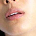 Close-up of lips wearing Ere Perez Acai Lip Pencils 1.1g in shade Shy, a natural taupe. Hydrating formula delivers smooth, moisturized lips. Text at bottom: shade shy | natural taupe.