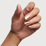 Hand modelling Sienna Byron Bay Divine nail polish, a luminous champagne-gold metallic shade.
