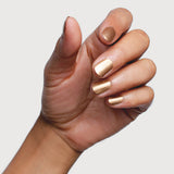 Hand modelling Sienna Byron Bay Divine nail polish, a luminous champagne-gold metallic shade.