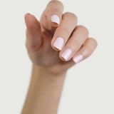 Close-up of a hand wearing Sienna Byron Bay Enlightened nail polish, showing the pale blush manicure shade on natural nails.
