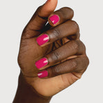 A deep-brown hand with fingers loosely curled to display glossy raspberry-pink nails painted in Sienna Byron Bay Goddess.