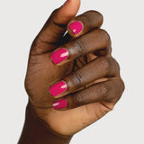 A deep-brown hand with fingers loosely curled to display glossy raspberry-pink nails painted in Sienna Byron Bay Goddess.