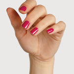 A light-skinned hand with fingers loosely curled to display glossy raspberry-pink nails painted in Sienna Byron Bay Goddess.