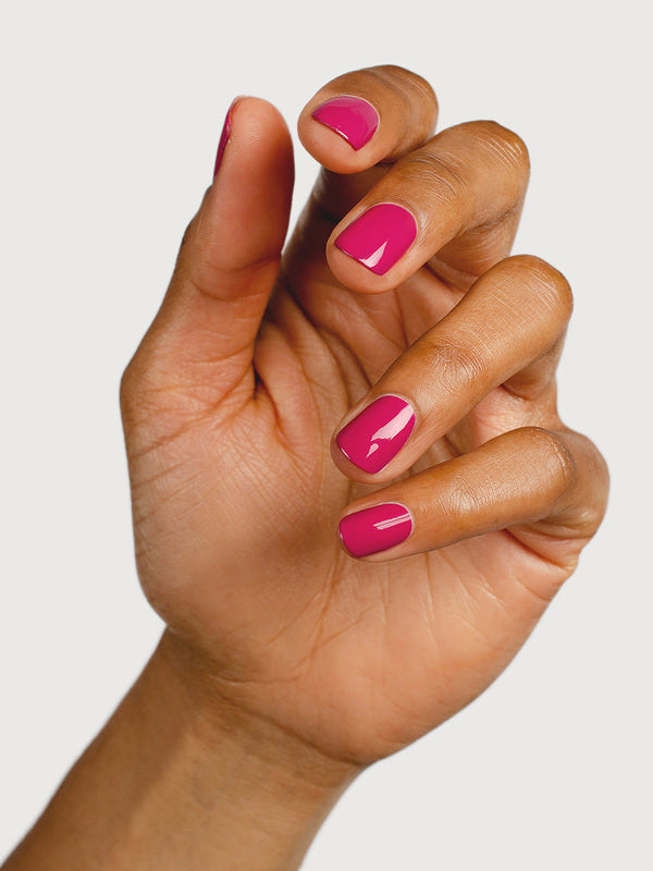 A medium-brown hand with fingers loosely curled to display glossy raspberry-pink nails painted in Sienna Byron Bay Goddess.