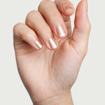 Close-up of a hand wearing Sienna Byron Bay Believe nail polish in a pale shimmering neutral shade.