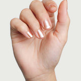 Close-up of a hand wearing Sienna Byron Bay Believe nail polish in a pale shimmering neutral shade.